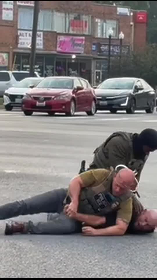 ICE Officer points a gun toward bystanders during an arrest in Hyattsville on Wednesday.